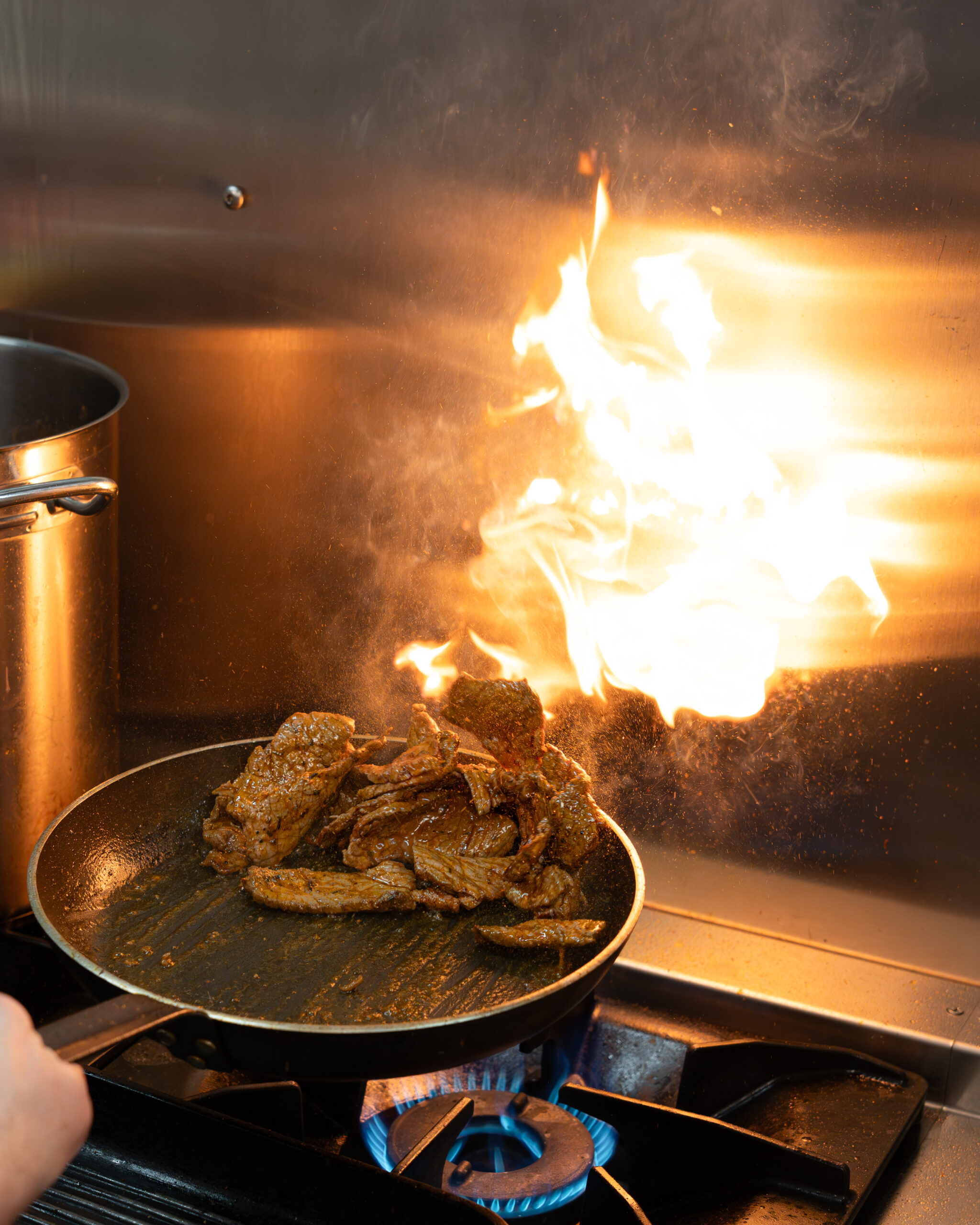Cuisine d'un restaurant en action, poêle flambée avec viande