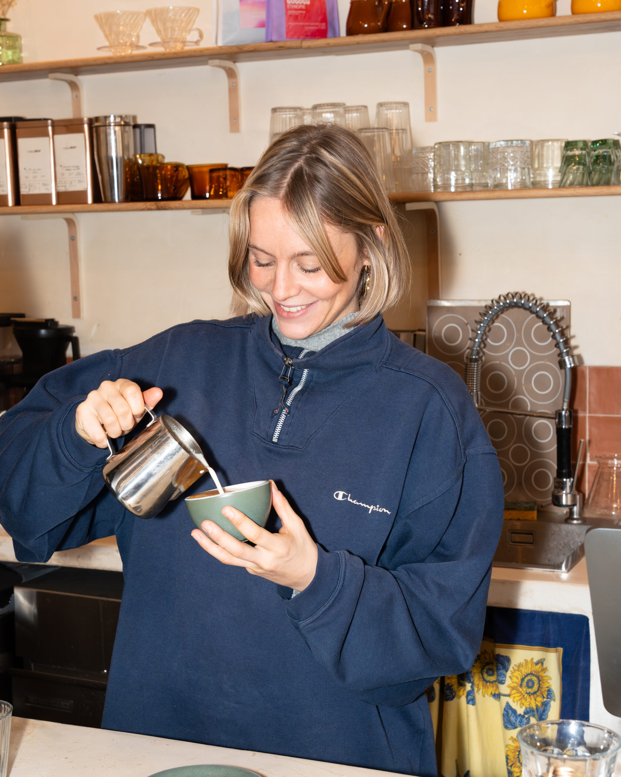 Jeune femme souriante réalisant un cappuccino 